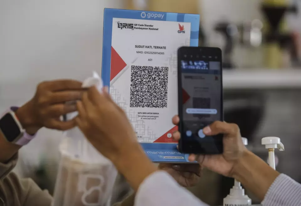 A buyer pays using QRIS at a coffee shop in Ternate, North Maluku, on April 24, 2025. (Antara Photo/Andri Saputra)