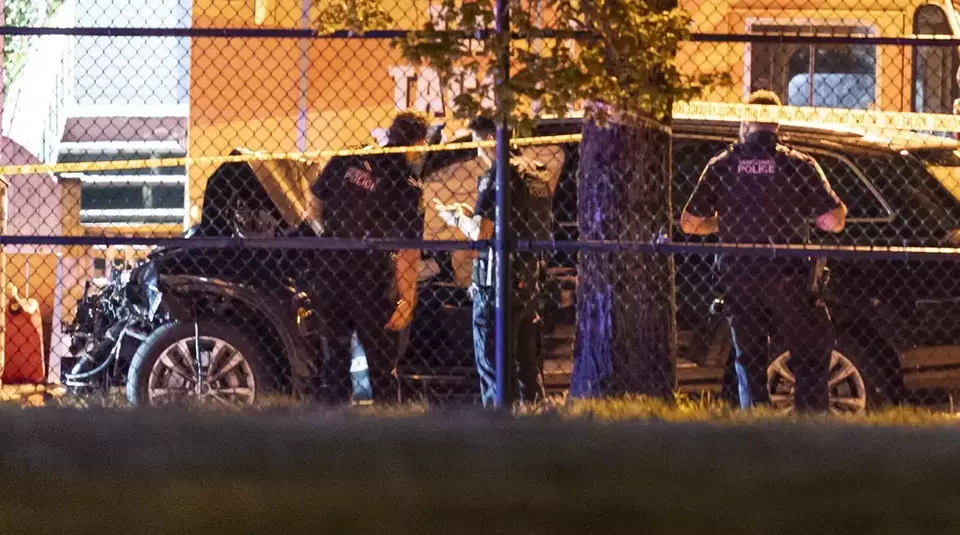 Vancouver police examine a black car suspected to be involved at a scene after a vehicle drove into a crowd at the Lapu Lapu Festival in Vancouver, British Columbia, Saturday, April 26, 2025. (Rich Lam/The Canadian Press via AP)