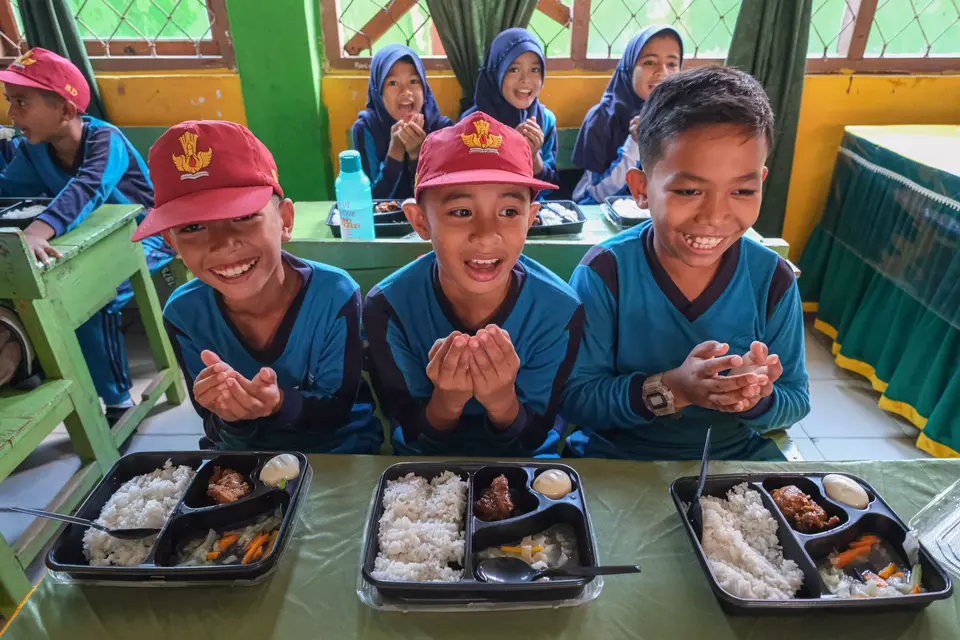 Children pray before eating the government-aided nutritious meals at an elementary school in Central Sulawesi on April 22, 2025. (Antara Photo/Andry Denisah)