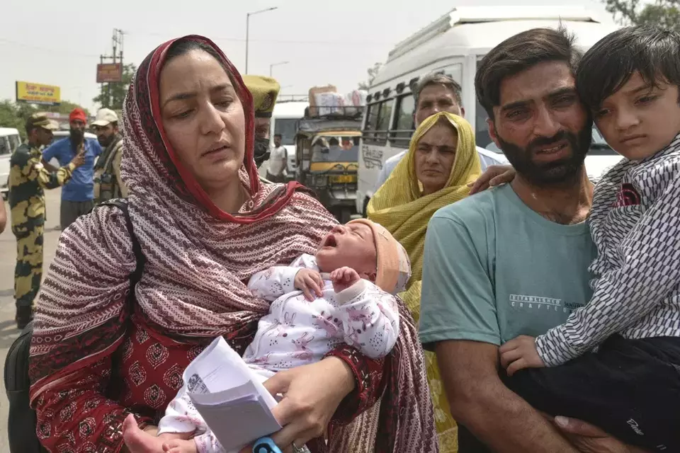 Pakistani national Sara Khan, left, married to Indian citizen Aurangzeb Khan, right, holding their children prepares to leave for Pakistan without her husband from the Attari-Wagah border between India and Pakistan, following New Delhi's decision to order almost all Pakistani citizens to leave the country after last week's deadly attack in Indian-controlled Kashmir, Wednesday, April 30, 2025. (AP Photo/Prabhjot Gill)