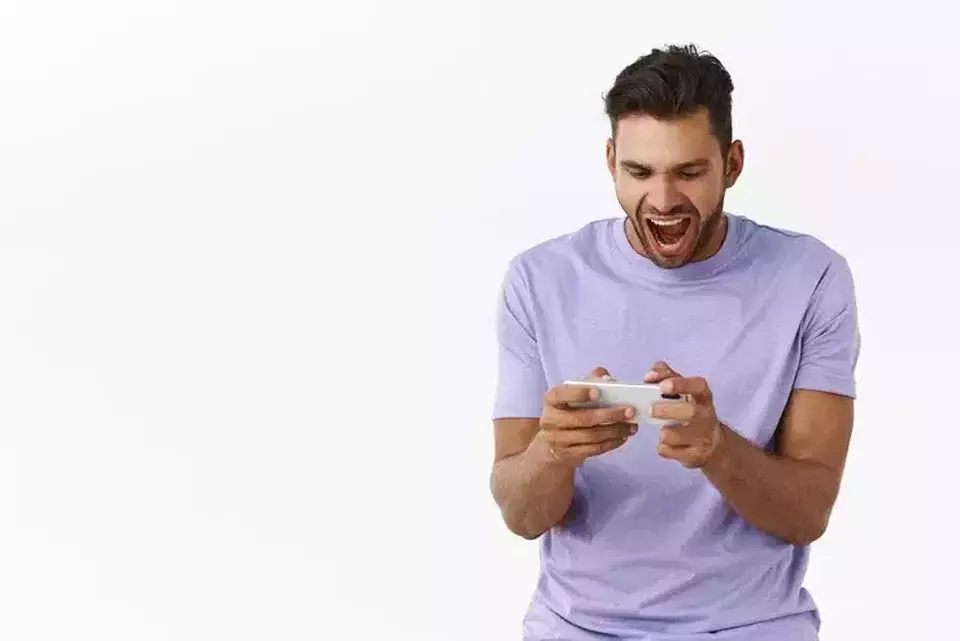 An illustration of a man playing video games on his phone. (Freepik)