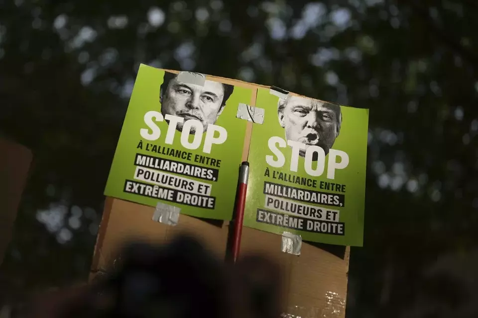 Protesters hold posters against Elon Musk, left, and US President Donald Trump during the May Day demonstration, Thursday, May 1, 2025, in Paris. (AP Photo/Thibault Camus)