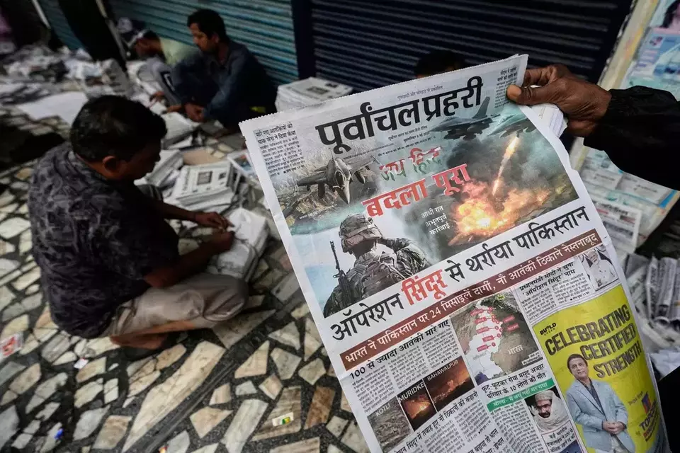 Vendors sort for distribution in Guwahati, India, news papers leading with reports of India firing missiles early Wednesday into Pakistani-controlled territory, Thursday, May 8, 2025. (AP Photo/Anupam Nath)

