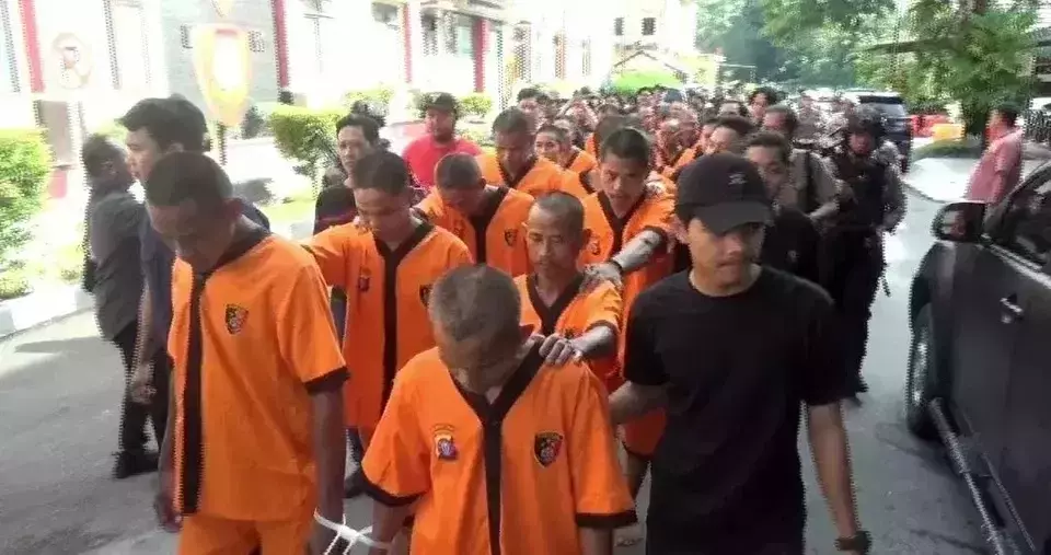 This screen capture from a video shows dozens of suspects being escorted by police for alleged palm fruit looting at a palm plantation in Central Seruyan District, Central Kalimantan, Tuesday, May 13, 2025. (Andre Faisal Rahman)