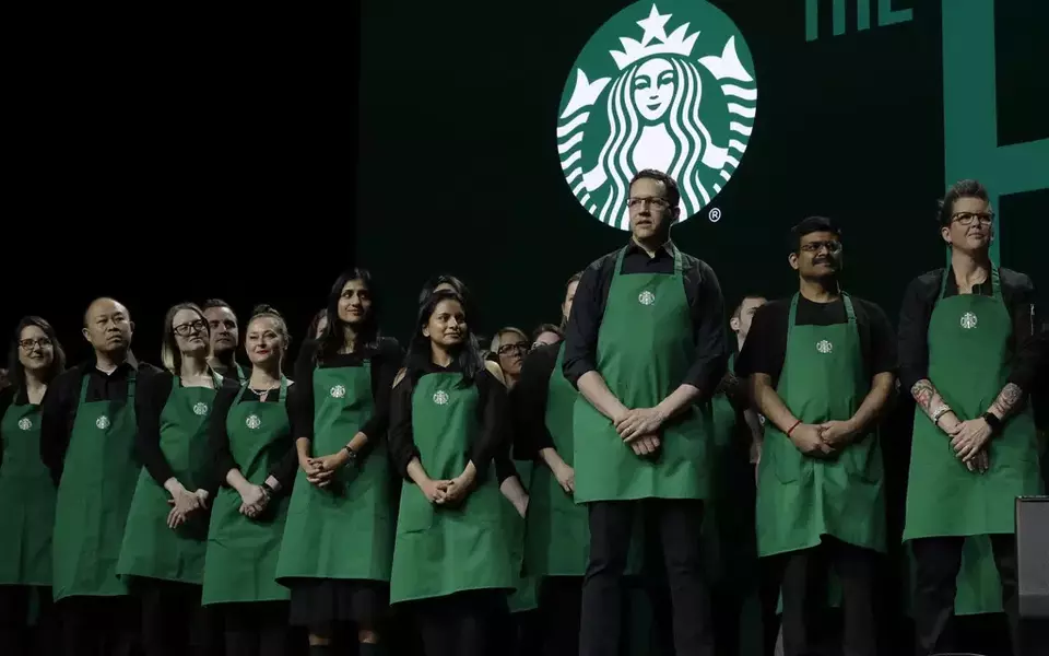 Starbucks baristas stand on stage, March 20, 2019, during an annual shareholders meeting in Seattle. (AP Photo/Ted S. Warren)