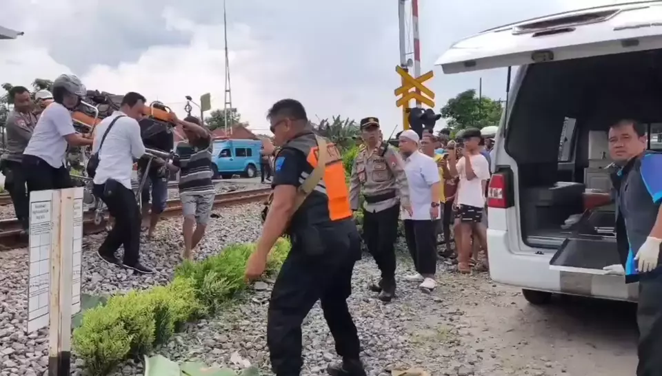 Paramedics evacuate the body of a motorcyclist who died after being hit by a train at a railway crossing in Magetan, East Java, Monday, May 19, 2025. (B-Universe Photo/Mustofa Pradana)