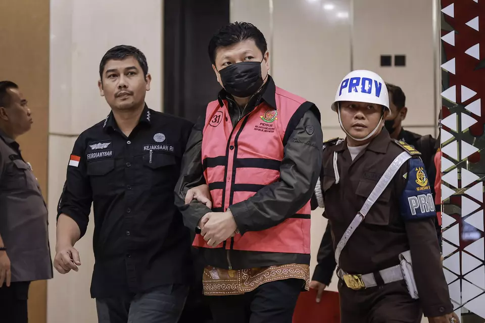 Iwan Setiawan Lukminto, former CEO of textile giant Sri Rejeki Isman (Sritex), center, is escorted by a security guard at the Attorney General's Office in Jakarta, Wednesday, May 21, 2025. (Antara Photo/Dhemas Reviyanto)