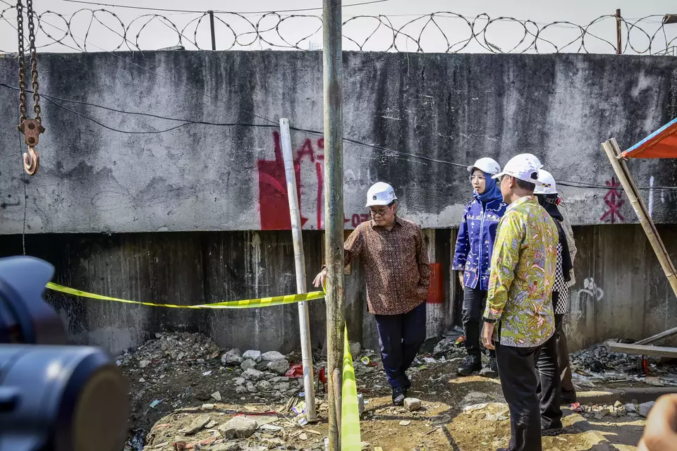 Jakarta Governor Pramono Anung, left, inspects a concrete wall that protects the Muara Angke area from tidal flooding, Thursday, June 12, 2025. (Antara Photo/Sulthony Hasanuddin)