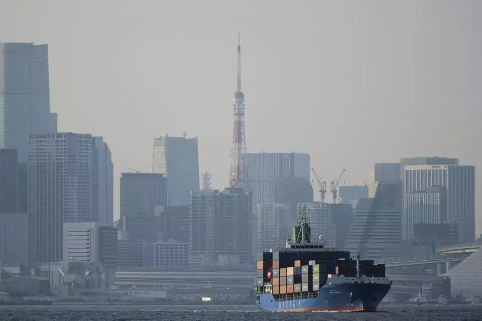 Tokyo Tower is seen amid tall buildings as a container ship leaves a cargo terminal in Tokyo, Wednesday, April 9, 2025. (AP Photo/Hiro Komae)

