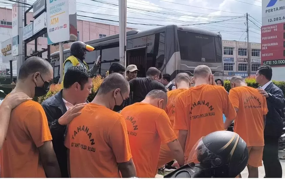 Officers of the Riau Provincial Police escort suspects in an online gambling syndicate in Pekanbaru, Riau, Wednesday, June 25, 2025. (B-Universe Photo/Effendi Rusli)