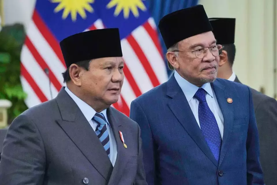 Malaysian Prime Minister Anwar Ibrahim, right, stands with Indonesian President Prabowo Subianto after a joint press conference at Merdeka Palace in Jakarta, Friday, June 27, 2025. (AP Photo/Achmad Ibrahim)