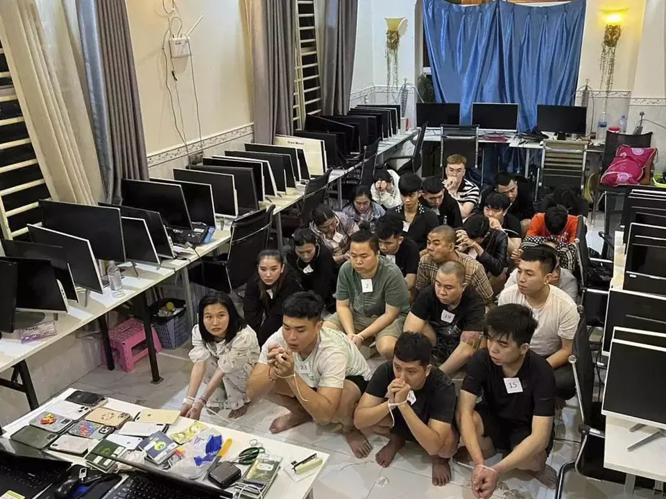 In this photo released by Agence Kampuchea Press (AKP), online scammers arrested by authorities squat in a building in Sihanoukville province, southwest of Phnom Penh, Cambodia, Tuesday, July 15, 2025. (AKP via AP)