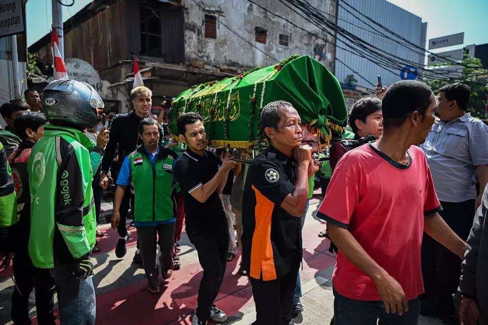 Residents carry the coffin of motorcycle taxi driver Affan Kurniawan for his funeral in Menteng, Jakarta, Friday, Aug. 29, 2025. Affan was fatally hit by a police armored vehicle during a violent rally in the capital the night before. (Antara Photo/Fauzan)