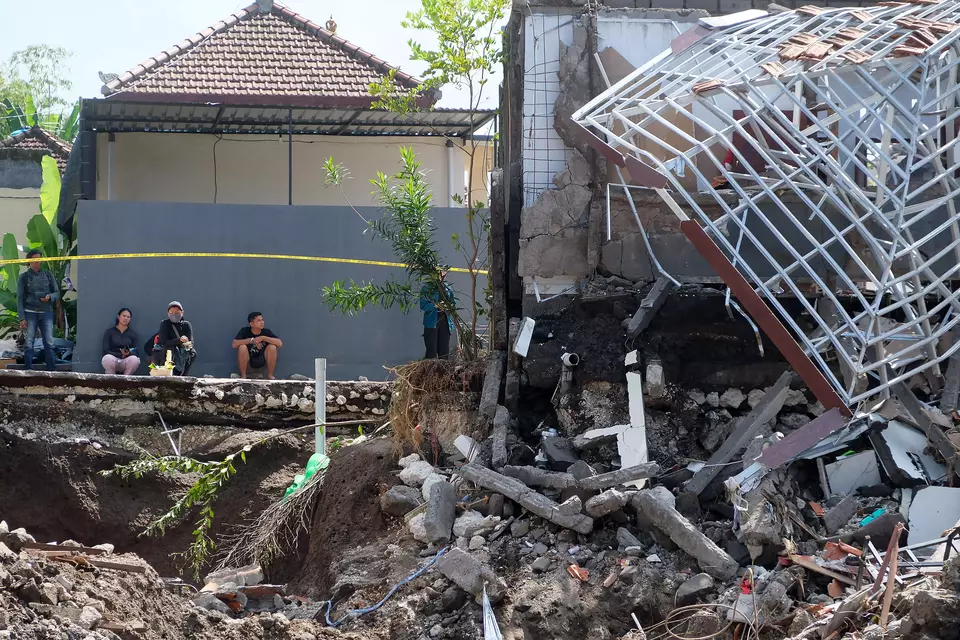 Residents pray near a collapsed house following floods at Permata Residence in Mengwitani, Badung, Bali, Saturday, Sept. 13, 2025. (ANTARA/Nyoman Hendra Wibowo)