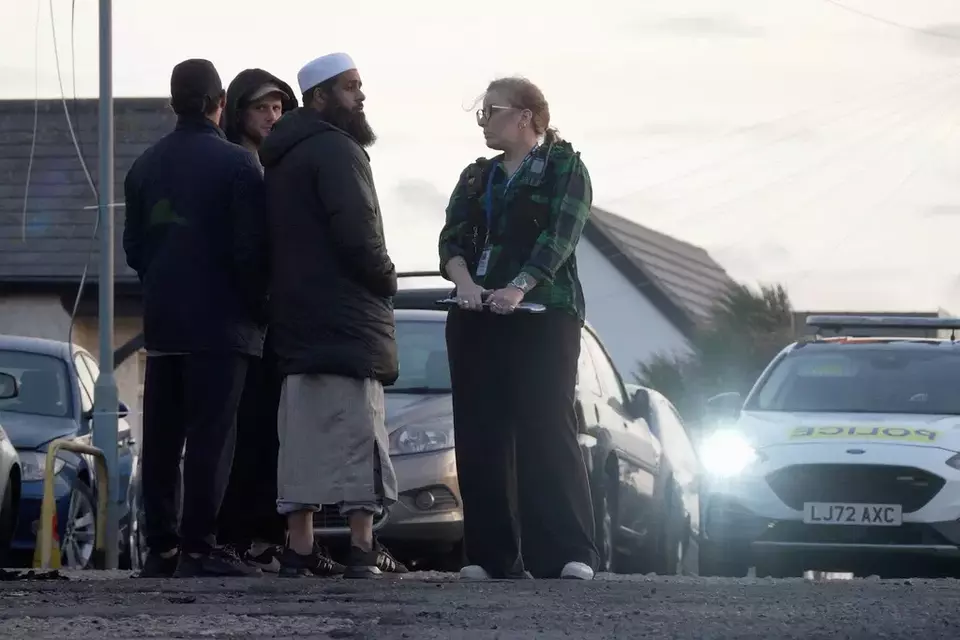 Locals view the damage outside the front entrance of the mosque in Peacehaven, following a suspected arson attack, in East Sussex, England, Sunday, Oct. 5, 2025. (Jamie Lashmar/PA via AP)

