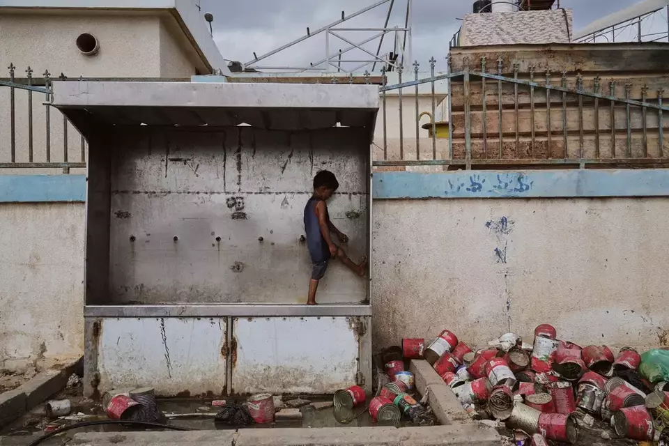 A child plays with water at a camp for displaced Palestinians in Deir al-Balah, Monday, Oct. 6, 2025. (AP Photo/Abdel Kareem Hana)

