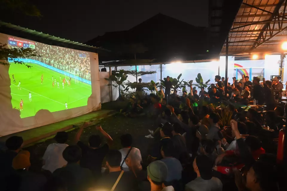 Fans watch a live broadcast of the 2026 World Cup Asian Qualifier match between Indonesia and Saudi Arabia at a coffee shop in South Tangerang, Banten, on Thursday, Oct. 9, 2025. (ANTARA FOTO/Rivan Awal Lingga).