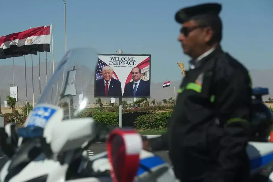A policeman stands on alert in front of a poster showing Egyptian President Abdel-Fattah el-Sissi and US President Donald Trump at the Red Sea city of Sharm el-Sheikh, Egypt, Monday, Oct. 13, 2025. (AP Photo/Amr Nabil)


