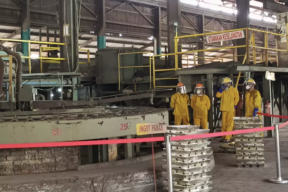 Several workers stand near molded tin ingots at the Tinindo Internusa tin smelter in Pangkalpinang, Bangka Belitung Islands, Monday, October 6, 2025. The smelter was seized by the state after being found to have conducted illegal mining in an area owned by state tin miner Timah. (Antara Photo/Aprionis)