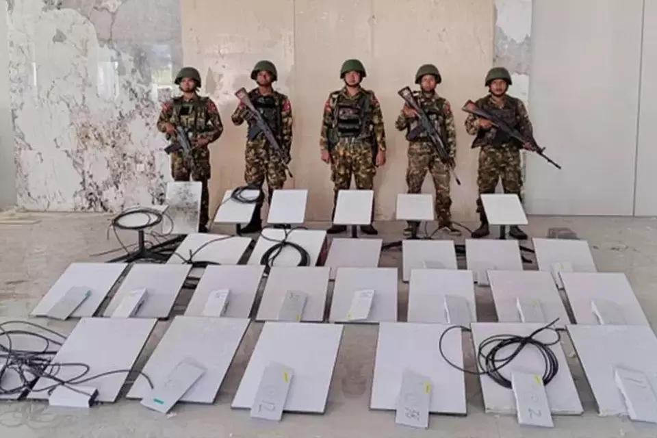 In this image provided by the Myanmar military on Oct. 19, 2025, soldiers stand next to Starlink machines as they seize KK Park online scam center in Myawaddy township, Karen State, Myanmar. (The Myanmar Military True News Information Team via AP)

