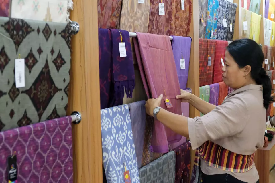 A woman arranges traditional Balinese woven fabrics at a small industry exhibition at Taman Budaya in Denpasar, Bali, on Thursday, Nov. 6, 2025. (Antara photo/Nyoman Hendra Wibowo) 

