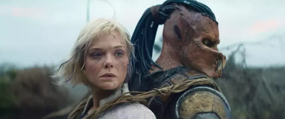This image released by 20th Century Studios shows Thia, portrayed by Elle Fanning, left, and Dek, portrayed by Dimitrius Schuster-Koloamatangi, in a scene from 'Predator: Badlands.' (20th Century Studios/Disney via AP)