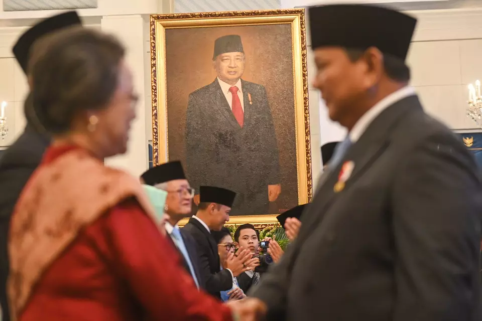 A large portrait of former President Soeharto is seen in the background as President Prabowo Subianto, right, greets his guests during the Heroes Day commemoration at the State Palace in Jakarta on Monday, Nov. 10, 2025. (Antara Photo/Aditya Pradana Putra)