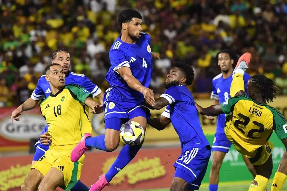 Curacao's Roshon Van Eijma, in the air, fights for the ball with Jamaica's Gregory Leigh, right, and Jonathan Russell during a World Cup 2026 qualifying soccer match in Kingston, Jamaica, Tuesday, Nov. 18, 2025. (AP Photo/Collin Reid)

