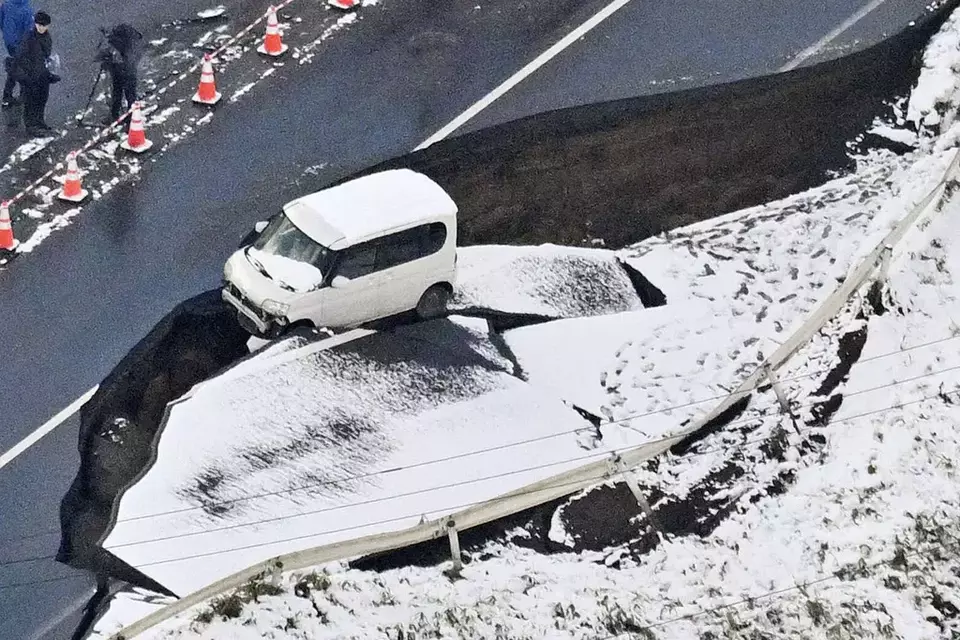 This aerial photo shows a vehicle sitting on a damaged road in Tohoku town, Aomori prefecture, northern Japan, Tuesday, Dec. 9, 2025, following a powerful earthquake on late Monday. (Kyodo News via AP)