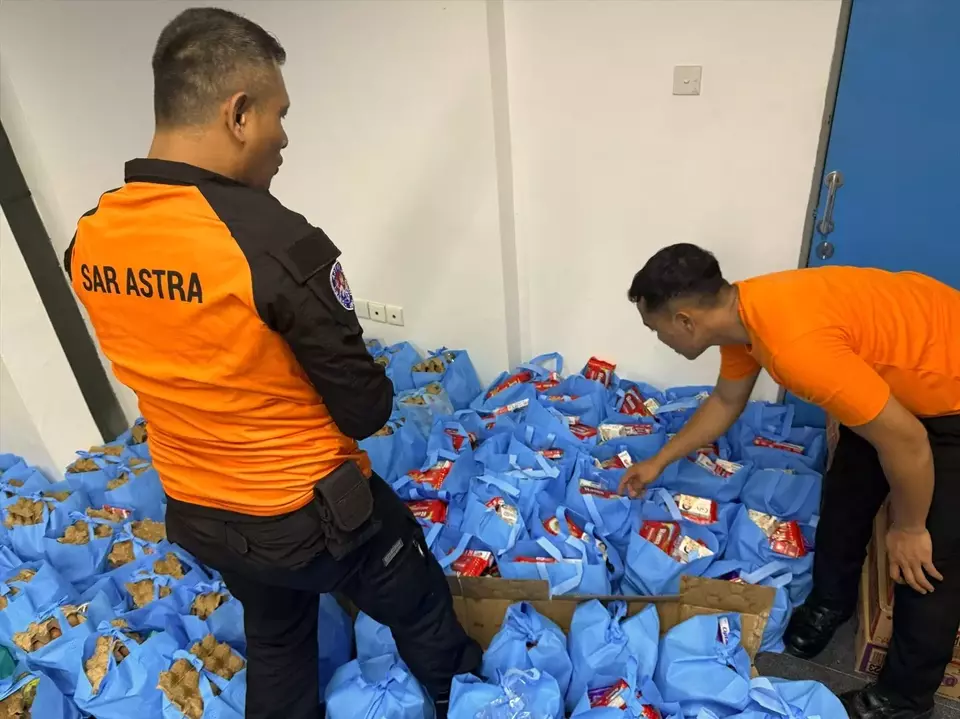 This undated photo shows Nurani Astra and volunteers distributing staple food aid to an evacuation center in West Sumatra. (Photo Courtesy of Astra)