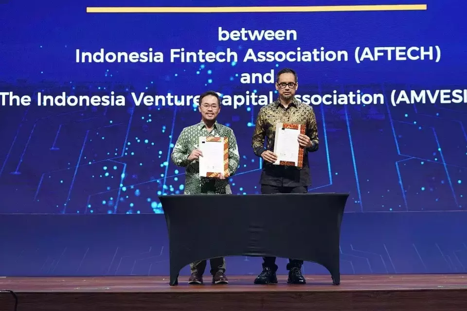AFTECH and AMVESINDO representatives hold signed MoU documents during the signing ceremony at Mandiri BFN Fest 2025.