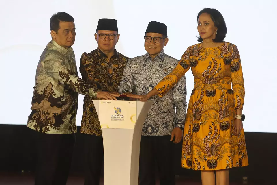Migrant Worker Protection Minister Mukhtarudin, second left, and Coordinating Minister for Community Empowerment Muhaimin Iskandar, second right, launch the  2025 International Migrants Day commemoration at Taman Mini Indonesia Indah in Jakarta on Thursday, December 18, 2025. (David Gita Roza)