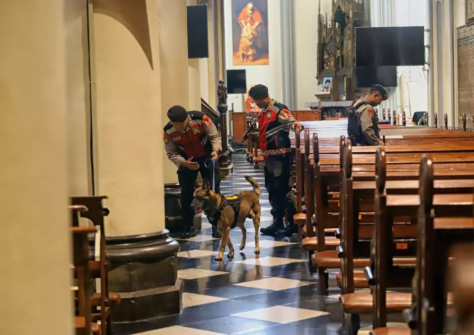 Police officers from Jakarta Metropolitan Police and K-9 units conduct security sweeps at Jakarta Cathedral on Tuesday, Dec. 23, 2025. (Berita Satu Photo/Joanito De Saojoao)