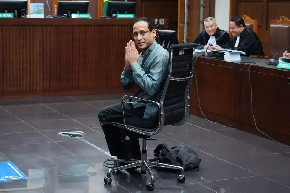 Nadiem Anwar Makarim, center, the co-founder of Indonesia's payments platform and ride-hailing company Gojek and former education minister, reacts as he enters the courtroom for his first trial hearing at the Corruption Court in Jakarta, Monday, Jan. 5, 2026. (AP Photo/Tatan Syuflana)