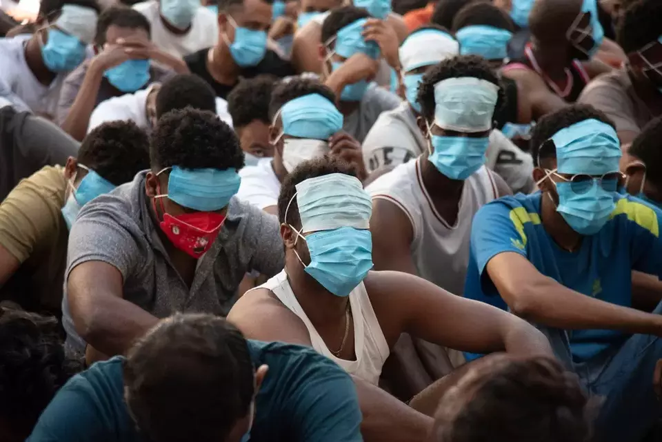 People from China, Vietnam and Ethiopia, believed to have been trafficked and forced to work in scam centers, sit with their faces masked while in detention after being released from the centers in Myawaddy district in eastern Myanmar, Feb. 26, 2025. (AP Photo/Thanaphon Wuttison)