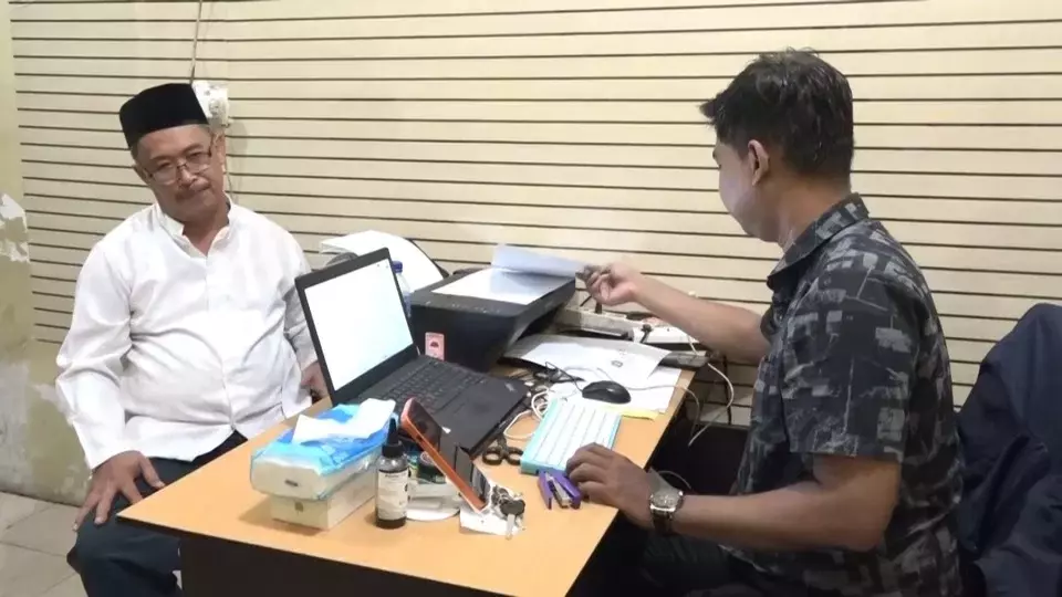 Amal Said, left, a lecturer at Universitas Islam Makassar, is interrogated by a policeman at the Tamalanrea District Police in Makassar, South Sulawesi, Tuesday, Dec. 30, 2025, for allegedly assaulting a female cashier. (B-Universe Photo/Irfandi)