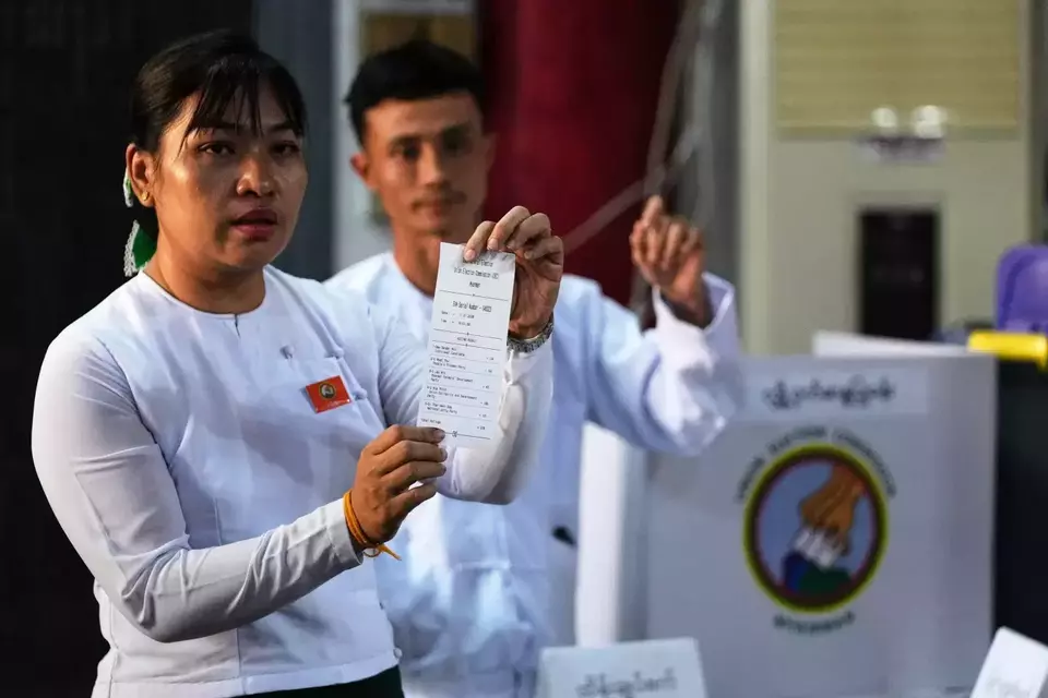 An official of the Union Election Commission shows a slip as they count ballots at a polling station during the second phase of general election in Yangon, Myanmar, on Jan. 11, 2026. (AP Photo/Thein Zaw)