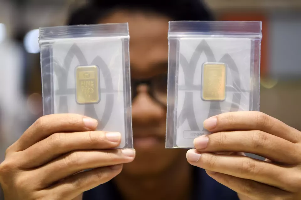 A salesperson shows gold bars at a gold sales outlet in Samarinda, East Kalimantan, Wednesday, Jan. 14, 2026. (Antara Photo/M Risyal Hidayat/YU).