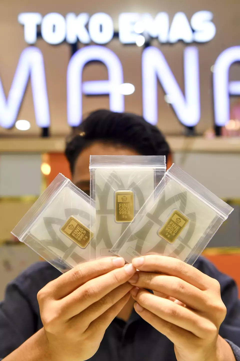 A salesperson displays gold bars at a gold sales outlet in Samarinda, East Kalimantan, Wednesday, Jan. 14, 2026. (Antara Photo/M Risyal Hidayat/YU)