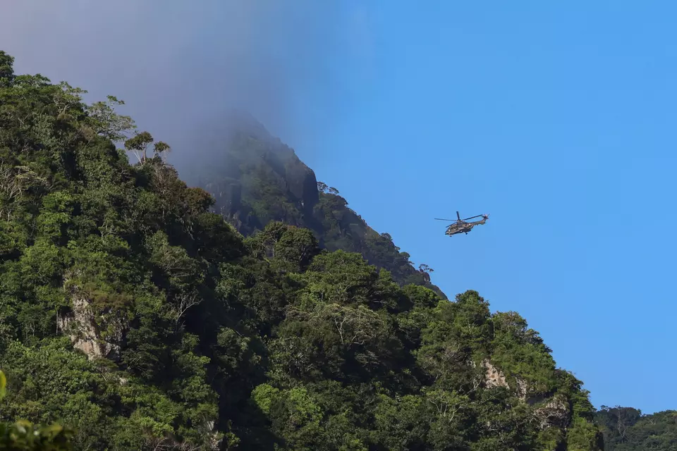 A helicopter belonging to the Indonesian Military hovers around a hill in Pangkajene Regency, South Sulawesi, on Sunday, Jan. 18, 2026, in search of a missing turboprop plane believed to have crashed in the area a day earlier. (Antara Photo/Arnas Padda)