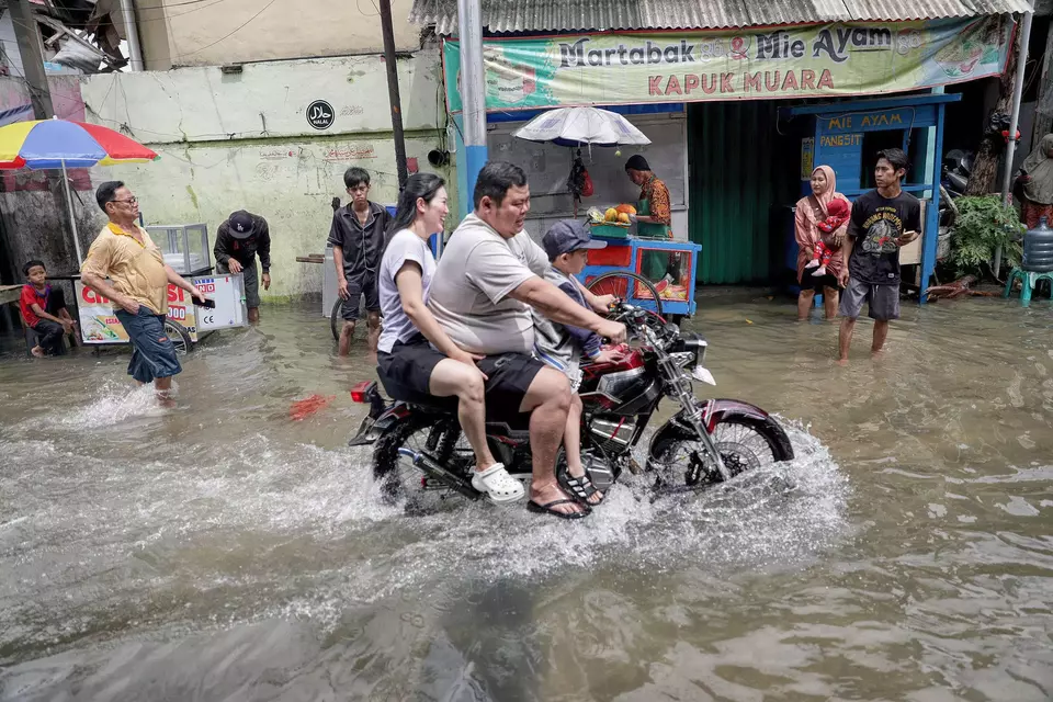 A motorcyclist braves a flooded road in Kapuk Muara, North Jakarta, on Sunday, Jan. 18, 2026. (B-Universe Photo/Joanito De Saojoao)