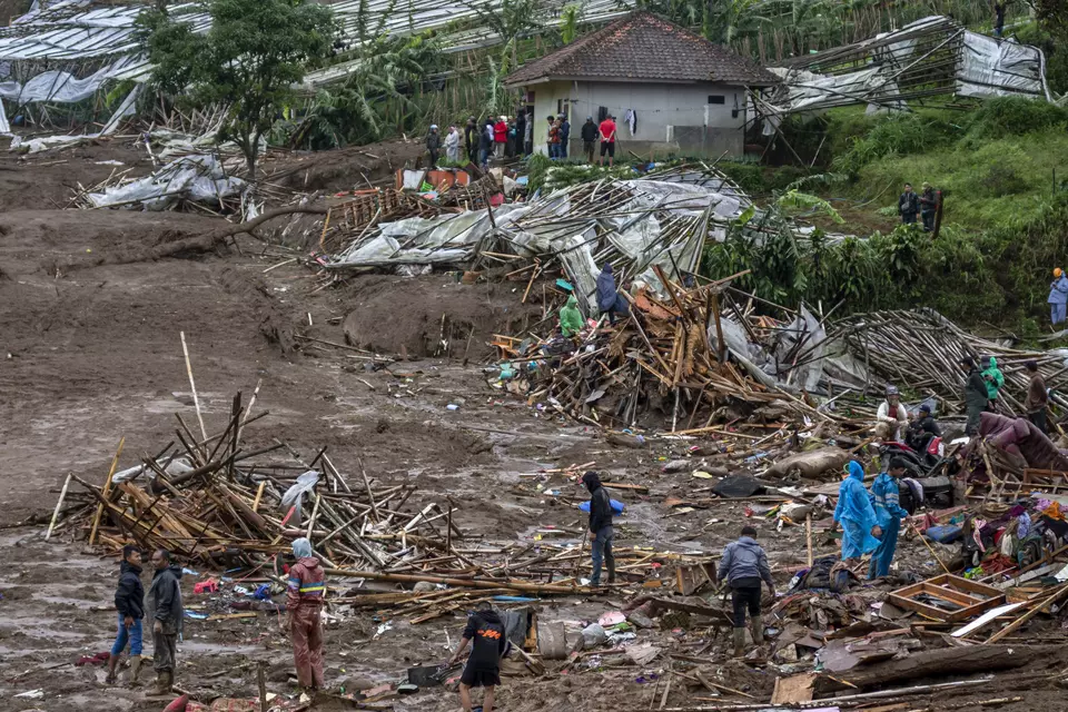 Rescue workers search through debris after a landslide sweeps away homes in Pasirlangu village, West Bandung, West Java, on Saturday, Jan. 24, 2026. (Antara Foto/Abdan Syakura)