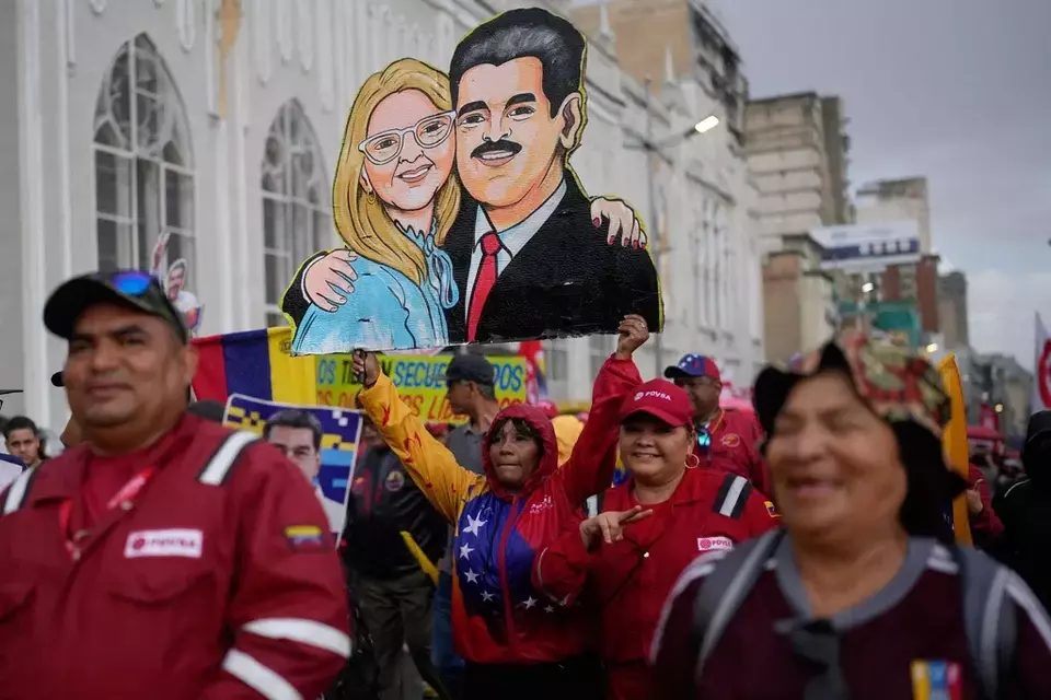 Government supporters carry a cutout of former President Nicolas Maduro and his wife Cilia Flores during a rally marking the anniversary of the 1958 coup that overthrew Venezuelan dictator Marcos Perez Jimenez, in Caracas, Venezuela, Friday, Jan. 23, 2026. (AP Photo/Ariana Cubillos)