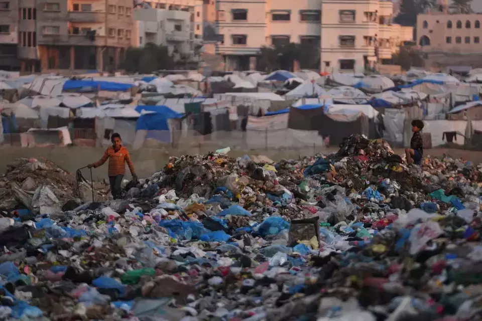Palestinian children sort through trash at a landfill in al-Bureij camp, in the central gaza Strip on Dec. 24, 2025. (AP Photo/Abdel Kareem Hana)