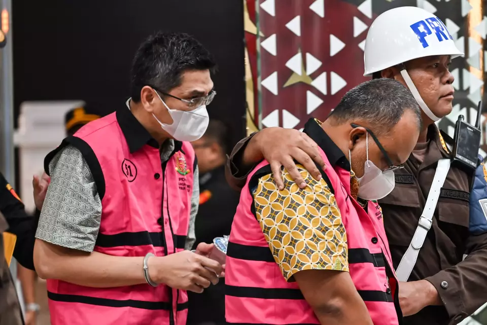 Pekanbaru Customs Office employee Muhammad Zulfikar, left, and Industry Ministry official Lila Harsyah Bakhtiar, center, are escorted after undergoing questioning as corruption suspects at the Attorney General's Office in Jakarta, Tuesday, Feb. 10, 2026. (Antara Photo/Fakhri Hermansyah)