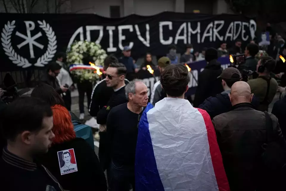 People hold a banner reading 'Goodbye comrade' as they take part in a march in Lyon, France, Saturday, Feb. 21, 2026, to pay tribute to Quentin Deranque, a 23-year-old nationalist activist who died from a beating after a clash between far-left and far-right supporters. (AP Photo/Laurent Cipriani)