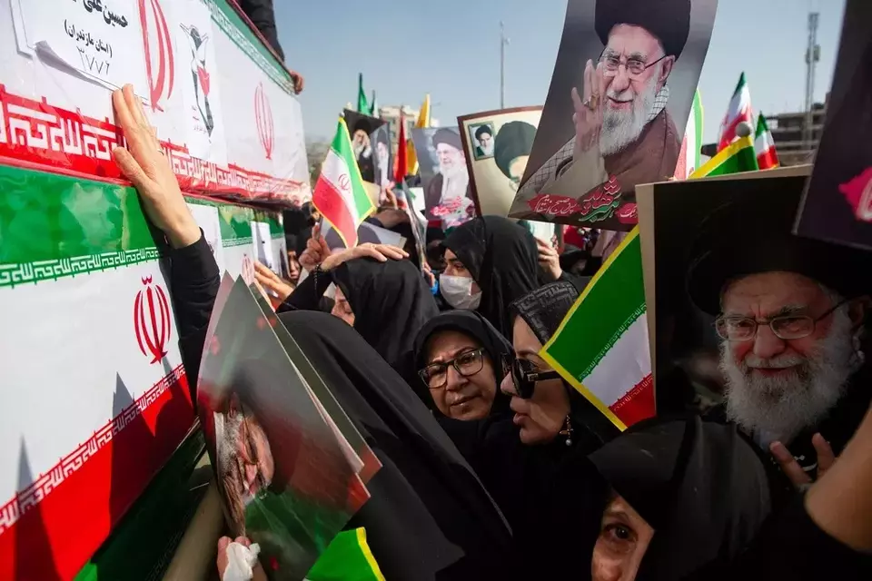 Mourners reach out to coffins during a funeral for people killed during the ongoing US-Israeli military campaign, with some holding pictures of the late Iranian Supreme Leader Ayatollah Ali Khamenei, in Isfahan, Iran, Thursday, March 5, 2026. (Payman Shahsanaei/ISNA via AP)