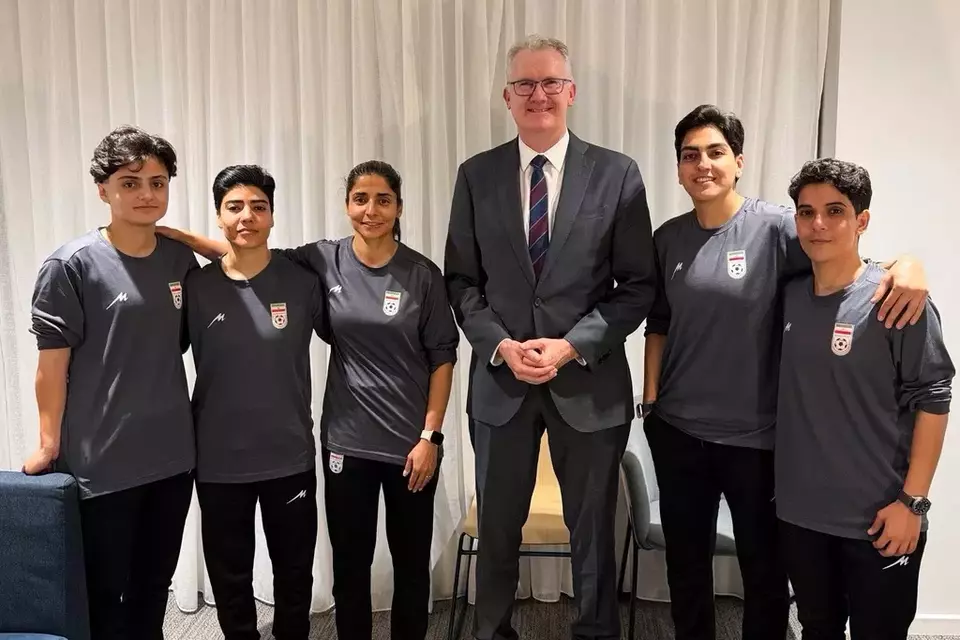 In this photo supplied by Australia's Minister for Home Affairs Tony Burke's office, the Minister Tony Burke, center, poses in an undisclosed location with five Iranian women soccer players who have been granted asylum in Australia, Tuesday, March 10, 2026. (Australia Ministry of Home Affairs via AP)

