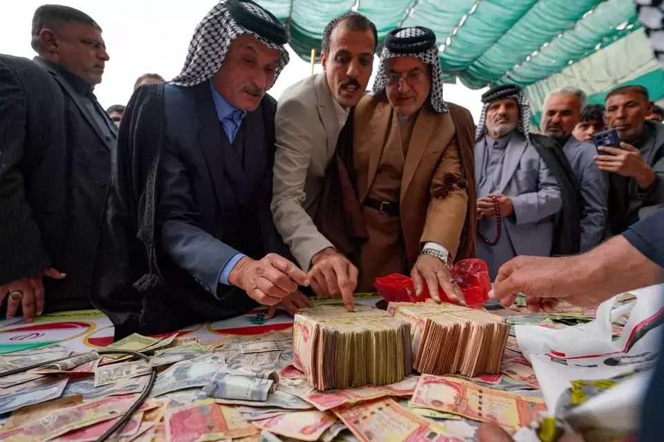 People donate money following a call by Grand Ayatollah Ali al-Sistani to support Iran and Lebanon during the war with the US and Israel, Friday, March 27, 2026, in Babylon, Iraq. (AP Photo/Anmar Khalil)